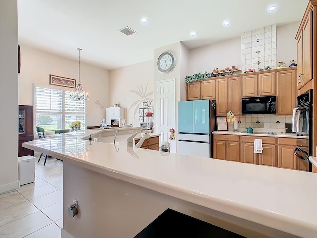 kitchen featuring pendant lighting, an inviting chandelier, light tile patterned floors, black appliances, and decorative backsplash