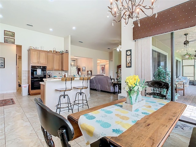 dining area with light tile patterned floors and ceiling fan with notable chandelier