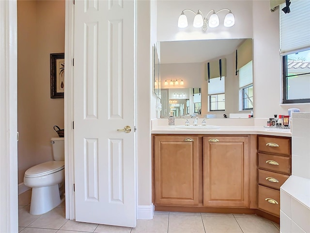 bathroom with toilet, tile patterned floors, and vanity