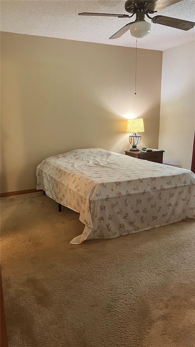 bedroom with ceiling fan, a textured ceiling, and carpet