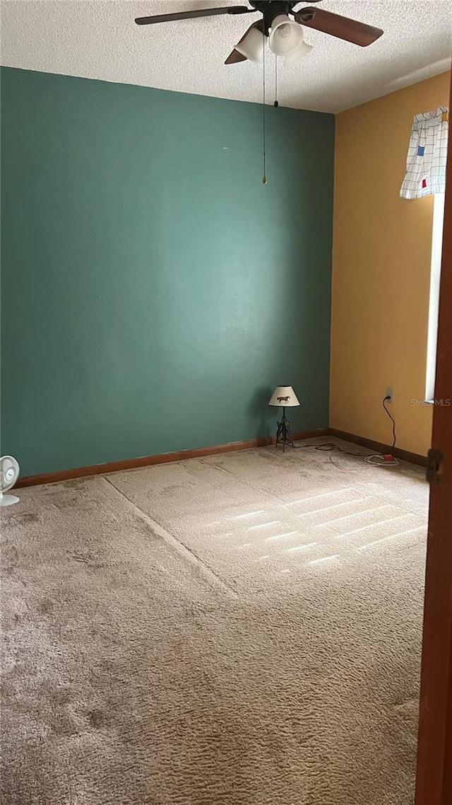 carpeted empty room featuring a textured ceiling and ceiling fan