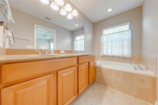 bathroom featuring plenty of natural light, double vanity, tiled tub, and tile patterned floors