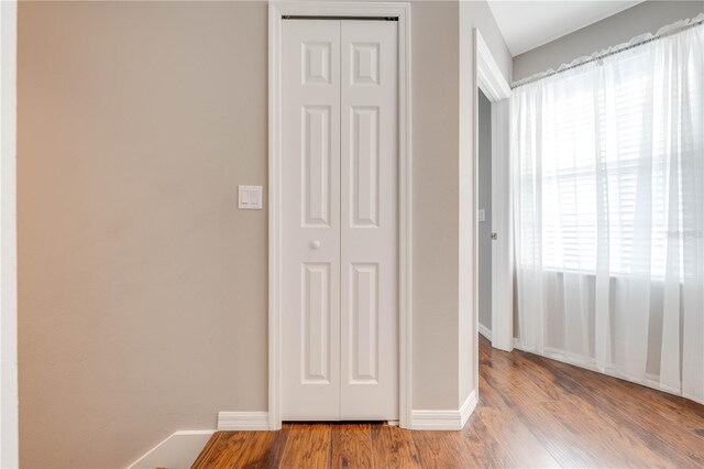 hallway with hardwood / wood-style flooring