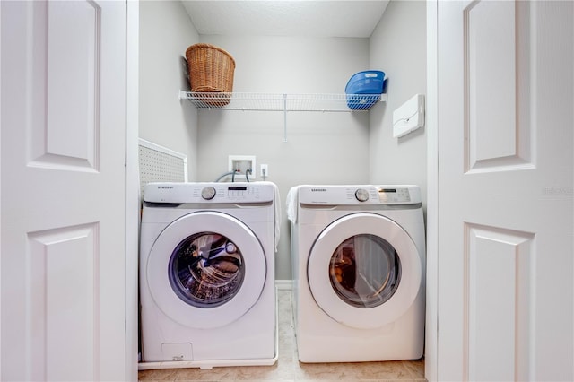 laundry room featuring independent washer and dryer and light tile patterned floors