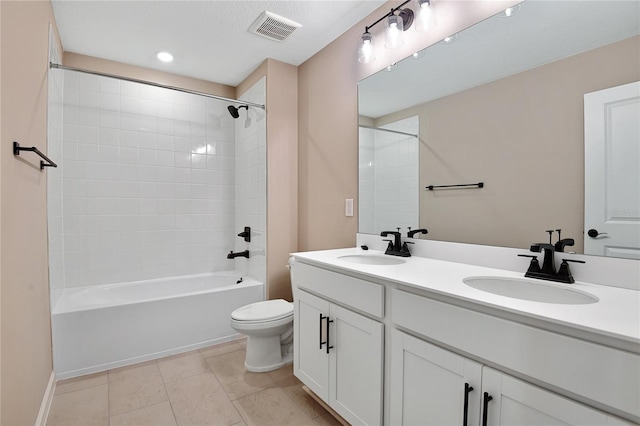 full bathroom featuring vanity, tiled shower / bath combo, tile patterned floors, and toilet