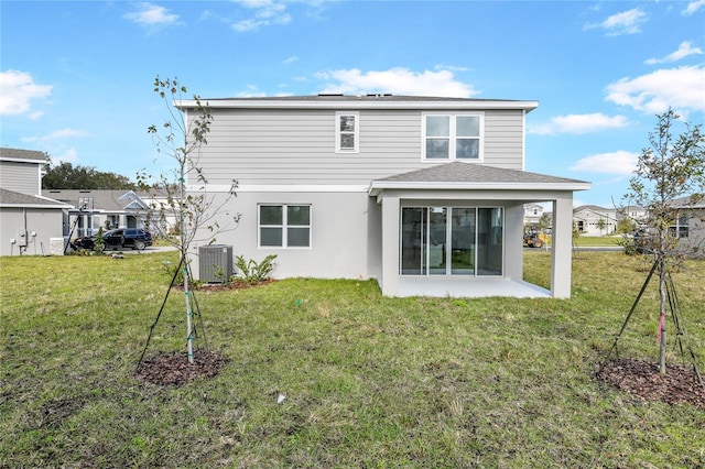 rear view of house with central AC, a patio, and a lawn