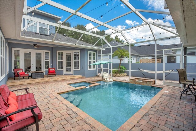 view of pool featuring ceiling fan, a patio, an in ground hot tub, a lanai, and french doors