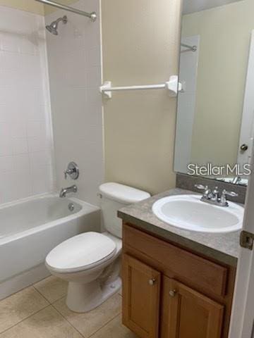 full bathroom with vanity, tiled shower / bath combo, tile patterned floors, and toilet