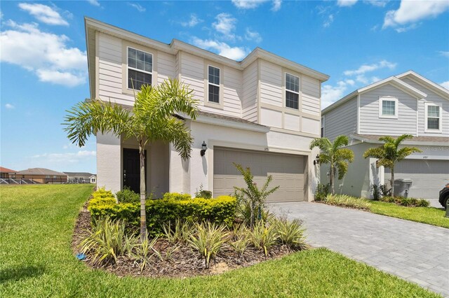 view of property with a garage and a front yard