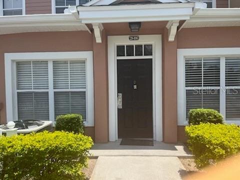 doorway to property featuring stucco siding