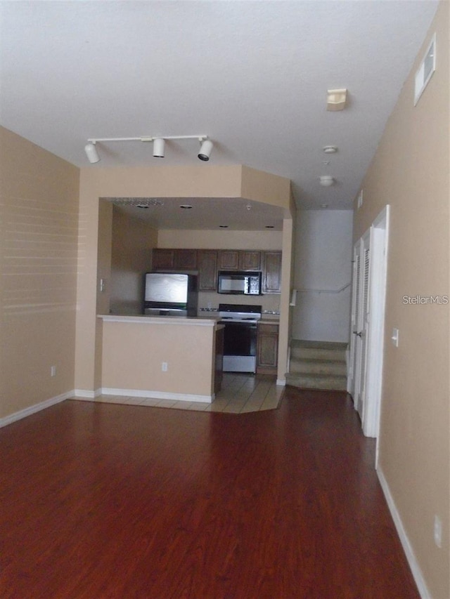 unfurnished living room with track lighting and hardwood / wood-style floors