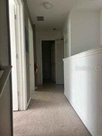 hallway featuring light colored carpet