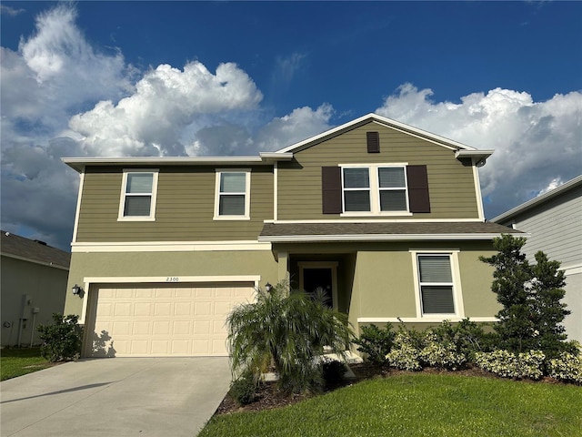 view of property with a garage and a front lawn