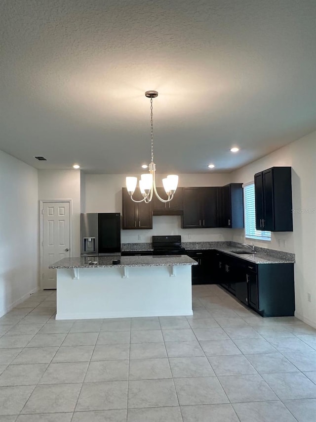 kitchen with stainless steel fridge with ice dispenser, range, sink, and light tile patterned floors