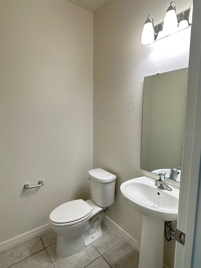 bathroom with toilet and tile patterned floors