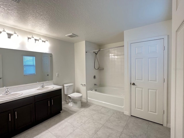 full bathroom featuring tiled shower / bath, a textured ceiling, tile patterned floors, toilet, and double sink vanity