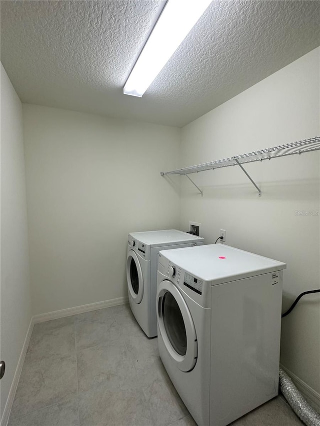 laundry area with a textured ceiling and independent washer and dryer