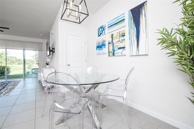 tiled dining area featuring a textured ceiling and ceiling fan with notable chandelier