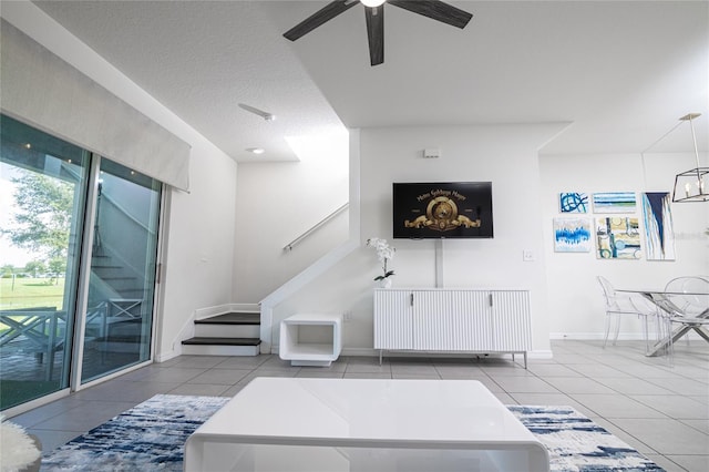 tiled living room with a textured ceiling and ceiling fan