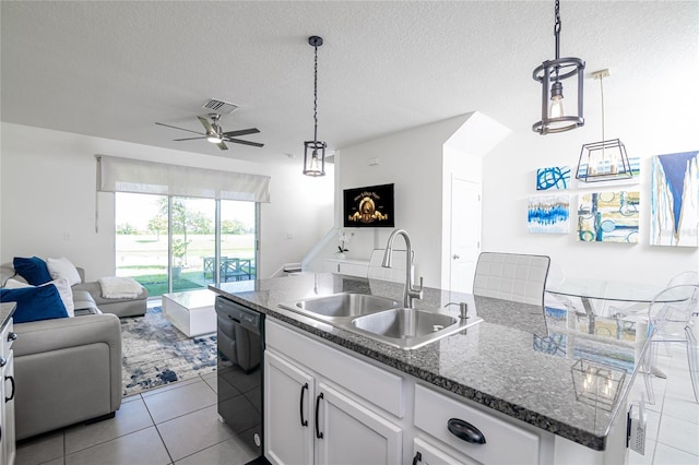 kitchen with black dishwasher, white cabinets, sink, an island with sink, and ceiling fan