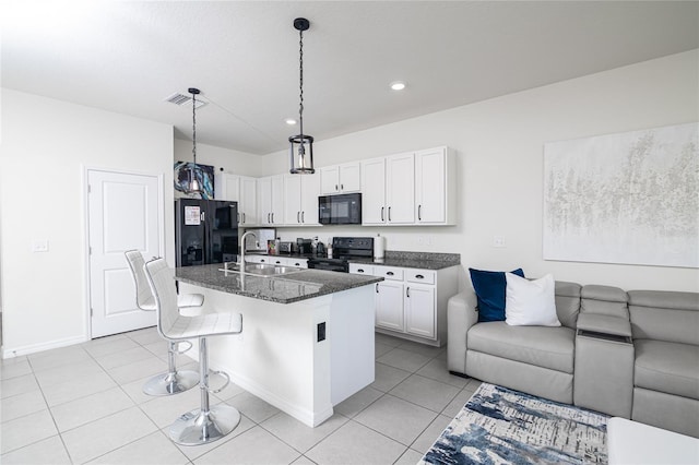 kitchen featuring black appliances, a center island with sink, a breakfast bar, sink, and white cabinetry