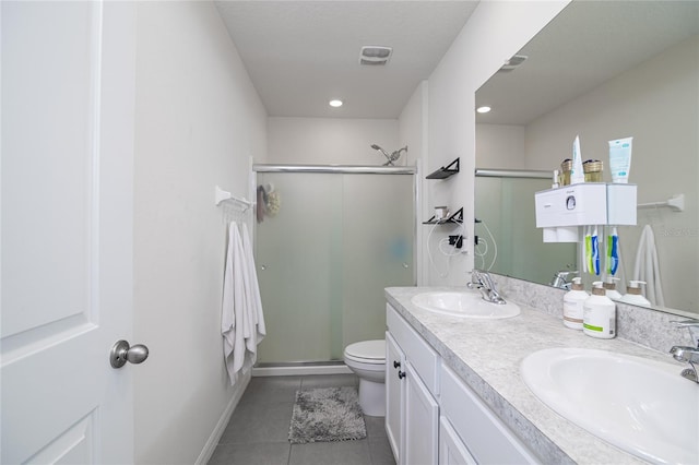 bathroom with tile patterned flooring, a shower with door, toilet, and dual bowl vanity