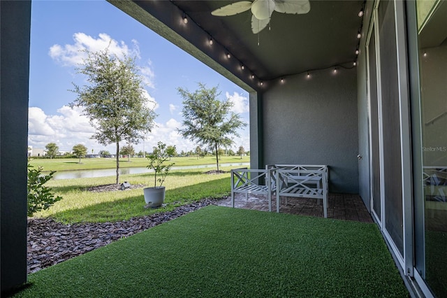 view of yard featuring a water view, a patio area, and ceiling fan