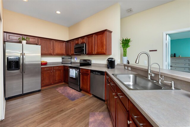 kitchen featuring stainless steel appliances, sink, and hardwood / wood-style flooring