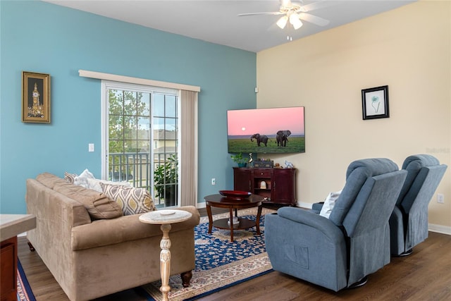 living room featuring dark wood-type flooring and ceiling fan