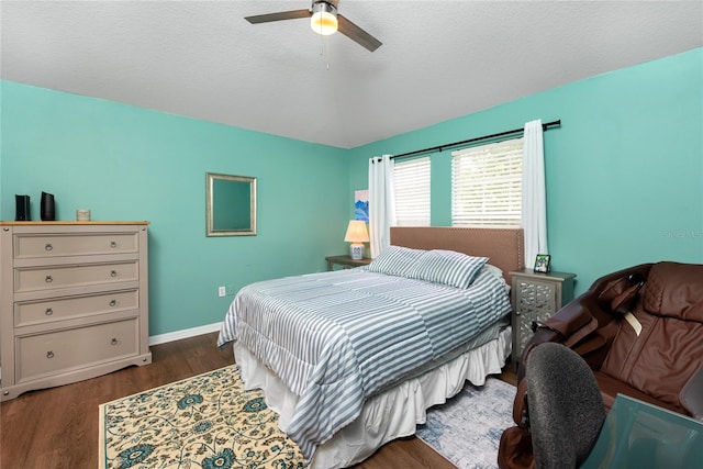 bedroom with a textured ceiling, dark hardwood / wood-style flooring, and ceiling fan