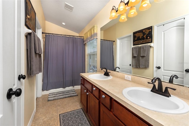 bathroom featuring a textured ceiling, dual bowl vanity, vaulted ceiling, tile patterned flooring, and an inviting chandelier