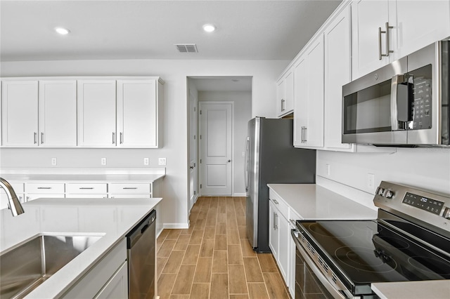 kitchen featuring stainless steel appliances, sink, and white cabinets