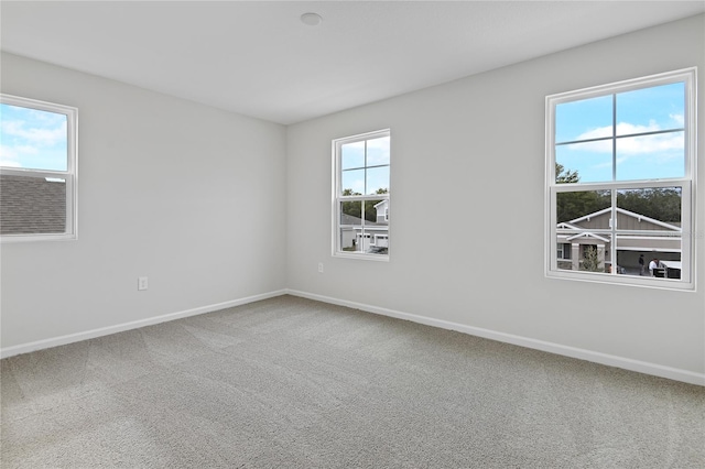 empty room with plenty of natural light and carpet floors