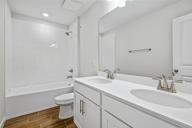 full bathroom with vanity, tiled shower / bath combo, and toilet