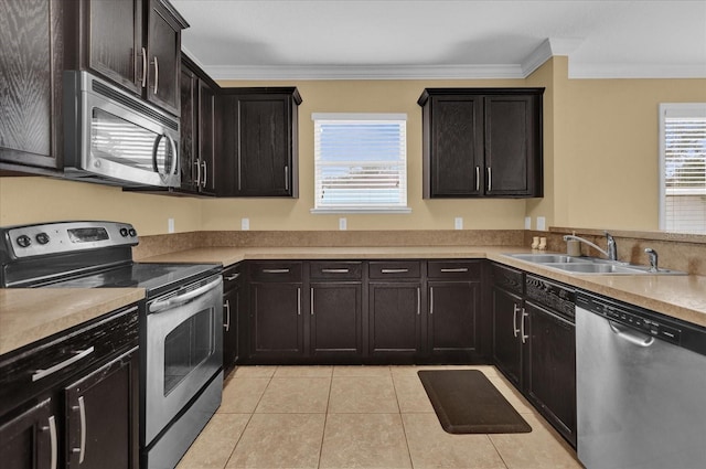 kitchen with light tile patterned floors, appliances with stainless steel finishes, crown molding, and sink