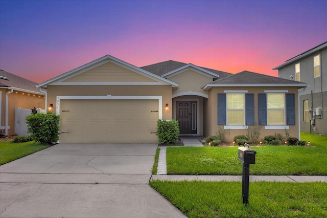 ranch-style house with a yard and a garage