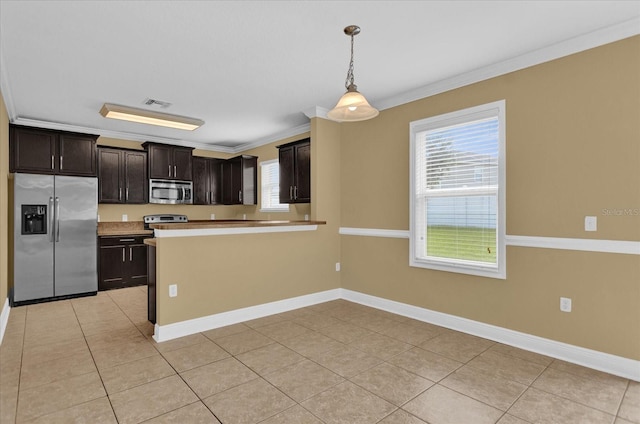 kitchen featuring ornamental molding, dark brown cabinets, hanging light fixtures, plenty of natural light, and appliances with stainless steel finishes