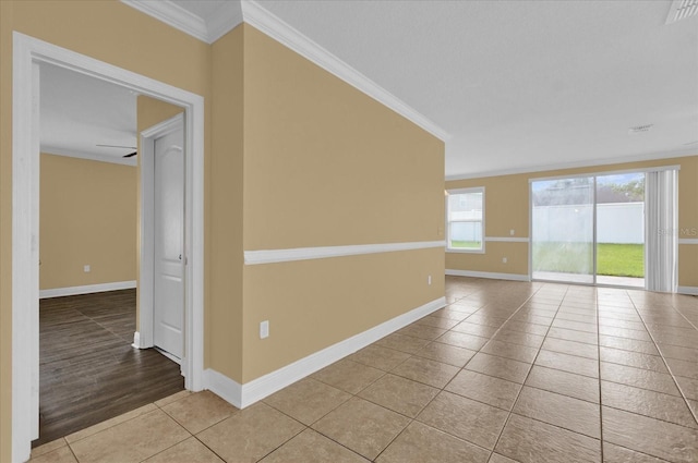 tiled spare room featuring crown molding