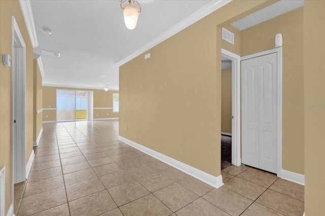 hallway featuring ornamental molding and light tile patterned floors