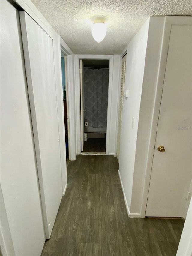 corridor featuring hardwood / wood-style floors and a textured ceiling