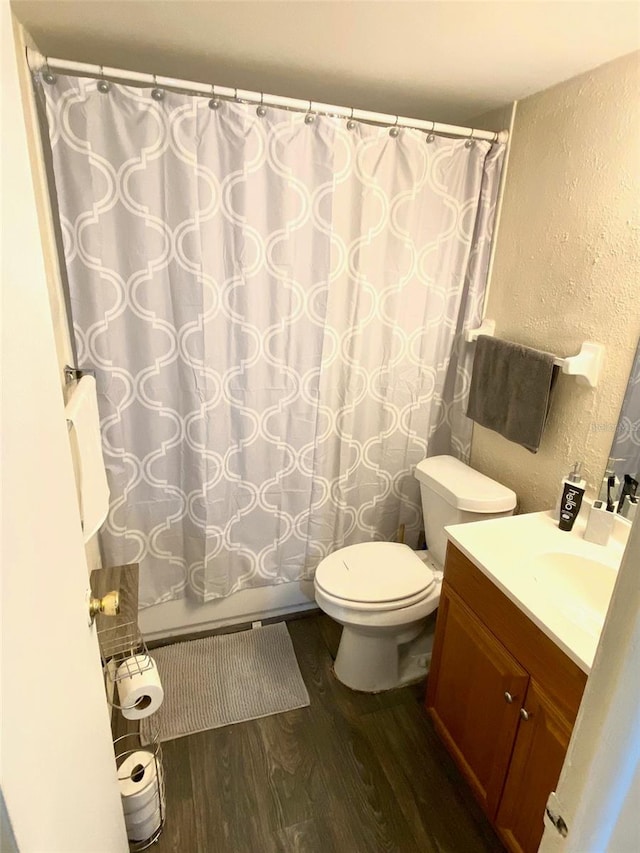 bathroom featuring wood-type flooring, vanity, and toilet