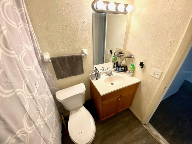 bathroom with wood-type flooring, vanity, and toilet