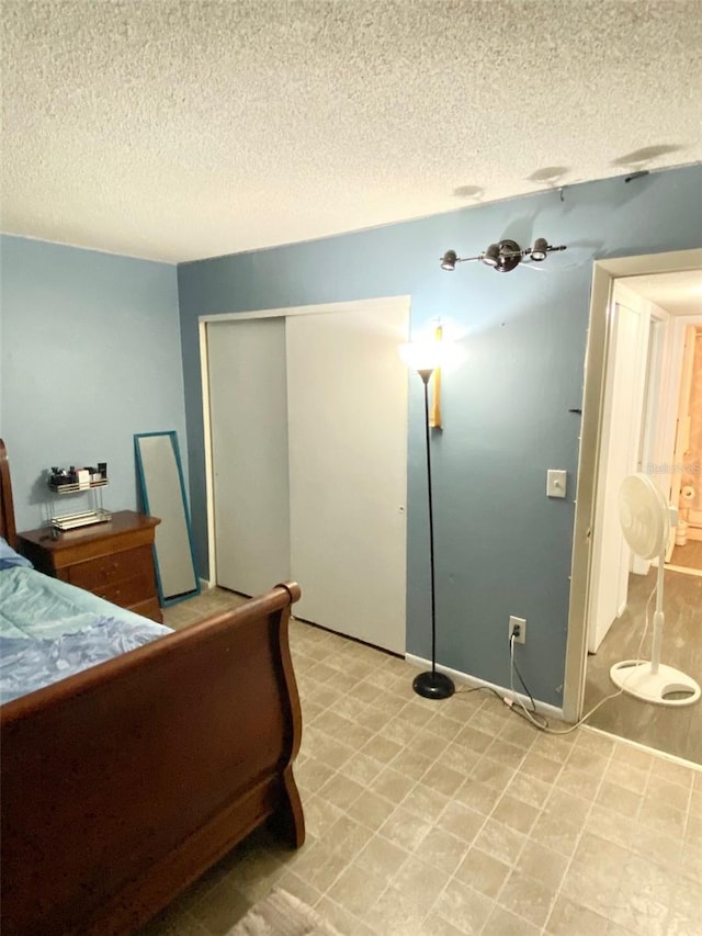 tiled bedroom with a textured ceiling and a closet