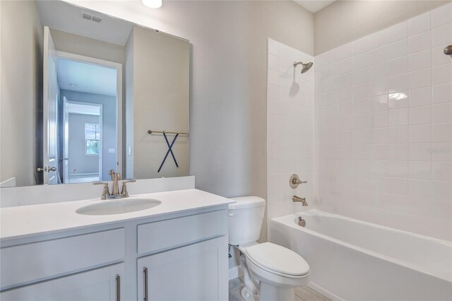 full bathroom with vanity, toilet, and tiled shower / bath combo