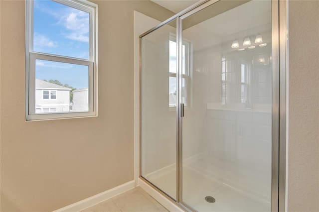 bathroom with a shower with door and tile patterned flooring