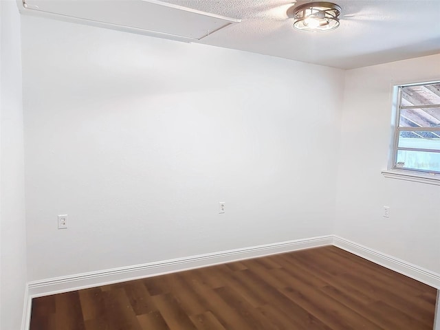 empty room with wood-type flooring and a textured ceiling