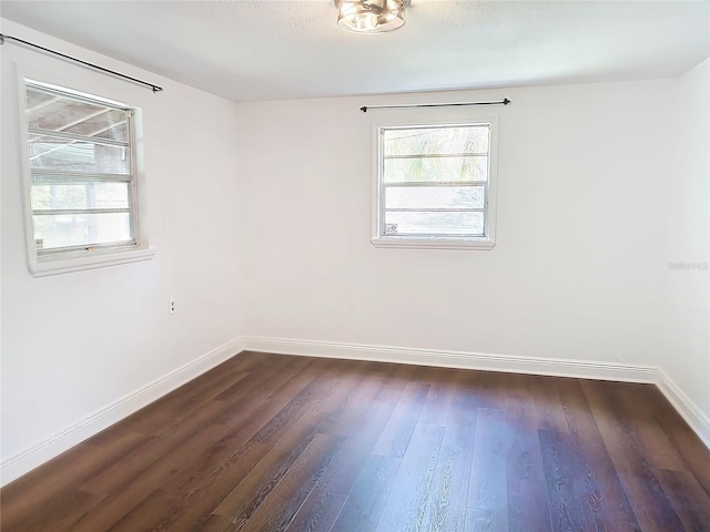 unfurnished room with dark hardwood / wood-style flooring