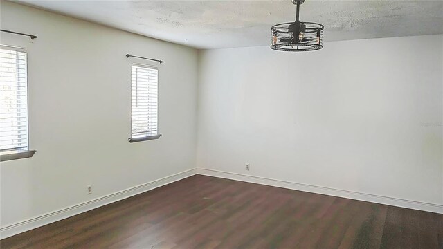 unfurnished room with a healthy amount of sunlight and dark hardwood / wood-style flooring