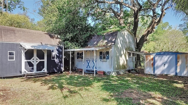 rear view of house with a storage shed and a lawn