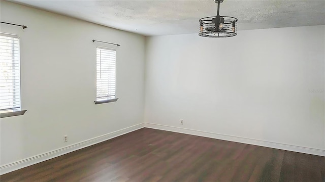 unfurnished dining area with dark wood finished floors and baseboards
